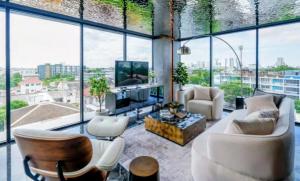 a living room with a lot of windows at Bangkok Esque Sukhumvit101 Condo NEW Building in Amphoe Phra Khanong