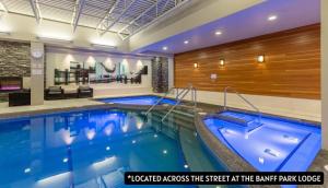 a swimming pool in a hotel lobby with a hotelaccess the street at the park at Peaks Hotel and Suites in Banff