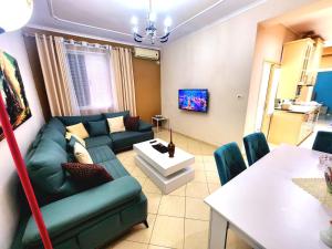 a living room with a blue couch and a table at Apartament me qira ditore "AGA"Fier in Fier +13 photos