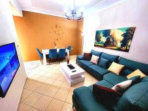 a living room with a blue couch and a table at Apartament me qira ditore "AGA"Fier in Fier