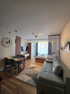 a living room with a couch and a table and a bed at SkyKop Apartmani in Kopaonik +113 photos