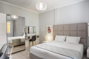 a bedroom with a bed and a desk and a mirror at Corfu City Center Design Residence incl private parking in Corfu