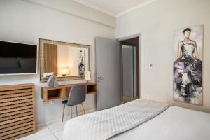 a bedroom with a bed and a desk and a mirror at Corfu City Center Design Residence incl private parking in Corfu +6 photos