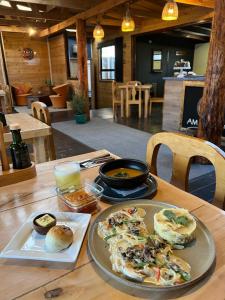 a wooden table with a plate of food on it at Hostal Amerindia in Puerto Natales