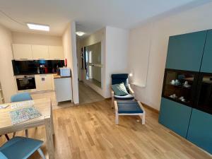 a living room with a table and chairs and a kitchen at Apartments Aarbergergasse - Self Check-In in Bern +19 photos