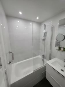 a white bathroom with a shower and a sink at Amadeus Hotel in Paris