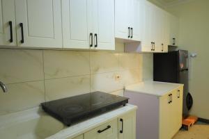 a kitchen with white cabinets and a stove at HD Residential Apartment , Bole Dembel in Addis Ababa