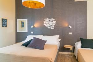 a bedroom with two beds and a chandelier at Hotel Rex - Lifestyle in Gabicce Mare