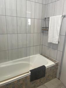 a bathroom with a bath tub and a towel at Flamingo Park D1 Langebaan in Langebaan +6 photos