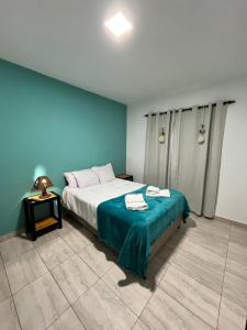 a bedroom with a bed with a blue wall at Cabana Alojamiento Turistico in Humahuaca