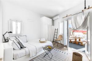 a white bedroom with a bed and a table at Casa Grande Santorini in Megalochori +80 photos