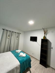 a bedroom with a bed and a flat screen tv at Cabana Alojamiento Turistico in Humahuaca