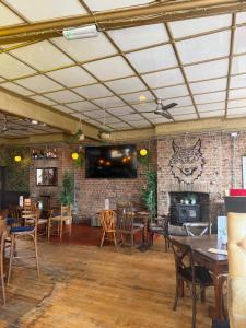 a restaurant with tables and chairs and a brick wall at The Wolfs Tavern in London