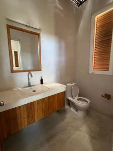 a bathroom with a toilet and a sink and a mirror at Poolside Cabaña Studio with stunning ocean view in Puerto Escondido