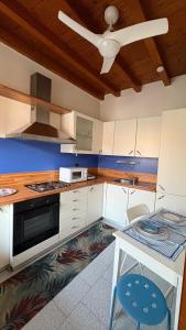 a kitchen with white cabinets and a ceiling fan at La casetta in Cesano Maderno