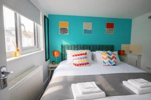 a bedroom with a bed with a blue wall at Brighton Colour Pop House- Sleeps up to 12 in Brighton & Hove