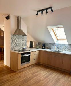 a kitchen with a stove and a sink and a window at Agroturystyka Nad Stawem in Centawa