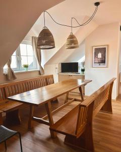 a dining room with a wooden table and benches at Agroturystyka Nad Stawem in Centawa