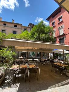 an outdoor patio with tables and chairs and umbrellas at Hostal Ripollès in Ripoll