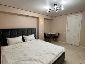 a bedroom with a large bed and a table at Meridian Hotel in Almaty