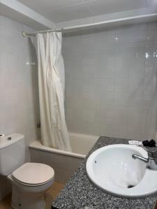 a bathroom with a sink and a toilet and a tub at Hostal Ripollès in Ripoll