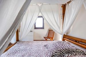 a bedroom with a canopy bed with a window at Sérénité in Jussac