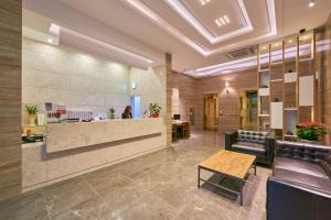 een lobby met een wachtkamer met een bank en een tafel bij Gwangju Madrid Hotel in Gwangju