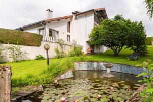 a garden with a pond in front of a house at Sérénité in Jussac