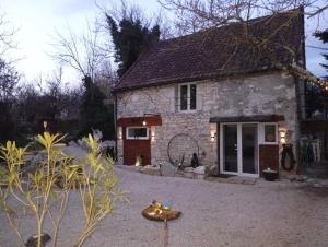 a stone house with a courtyard in front of it at L'harmonie des Oiseaux in Meyronne
