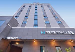 Un grand bâtiment avec un panneau en haut dans l'établissement Gwangju Madrid Hotel, à Gwangju
