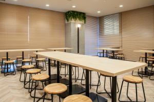 a row of tables and stools in a room at Hotel Il Fiore Kasai Annex in Tokyo
