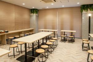 a room with tables and stools in a restaurant at Hotel Il Fiore Kasai Annex in Tokyo