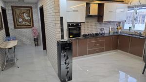 a kitchen with brown cabinets and a stove at Skyline Central Apartments in Islamabad