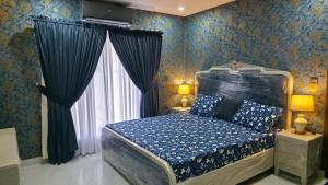 a bedroom with a canopy bed with blue wallpaper at Skyline Central Apartments in Islamabad