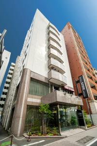 a tall white building on a city street at Hotel Il Fiore Kasai Annex in Tokyo