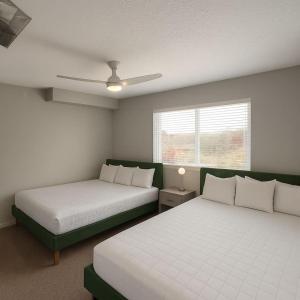 a bedroom with two beds and a ceiling fan at Axis Suite in Des Moines