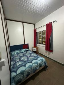 a bedroom with a bed and a window with red curtains at Casa em Alter do Chão in Santarém