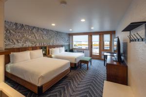 a hotel room with two beds and a television at Hotel Canoe and Suites in Banff +64 photos