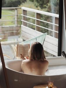 a woman sitting in a bath tub reading a book at Carrière Sauvage in Pont-Aven