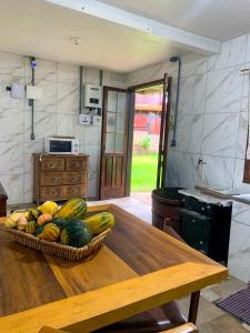 a bowl of fruit on a table in a kitchen at Cabana Refúgio do Recanto in São Valentim do Sul +2 photos