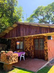a house with a table and a chair on a patio at Cabana Refúgio do Recanto in São Valentim do Sul