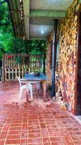 a table and a bench on a brick patio at Cabana Refúgio do Recanto in São Valentim do Sul