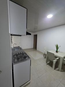 a kitchen with a stove and a table in it at El apartacho de Andres in Valledupar +20 photos