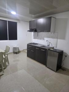 a kitchen with a sink and a stove in a room at El apartacho de Andres in Valledupar