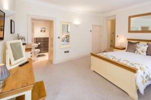 a bedroom with a bed and a desk and a bathroom at Hunter House Holiday Apartment - York in York
