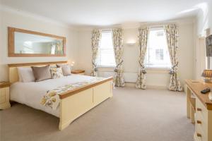 a bedroom with a large bed and two windows at Hunter House Holiday Apartment - York in York
