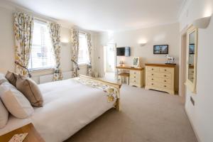 a bedroom with a bed and a desk and window at Hunter House Holiday Apartment - York in York
