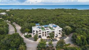 Eine Luftaufnahme eines Hauses mit dem Meer im Hintergrund in der Unterkunft Emma Apartments - Akumal-Grand Sirenis in Akumal