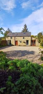 an old stone building with a large driveway at Acorn Cottage, Ashover in Ashover