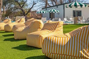 a group of yellow and white chairs sitting on the grass at Petit Cowboy in New Braunfels